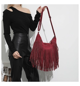 Detail of burgundy fringe tote bag featuring matte suede texture and adjustable strap