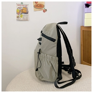 Seitenansicht des karierten Rucksacks mit elastischer Kordelzug-Seitentasche im Detail