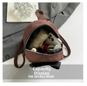 Interior view of brown suede mini backpack showing capacity for phone, umbrella and cosmetics