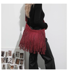Detail of burgundy suede tote bag featuring long tassels and bohemian fringe texture
