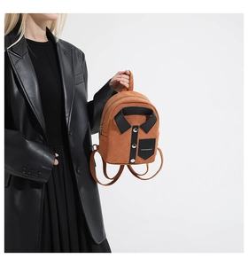 Detail of a brown suede mini backpack featuring a unique black shirt-style design and buttons