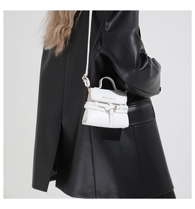 Détail du mini sac blanc avec texte doré et cuir à grain lychee pour femmes