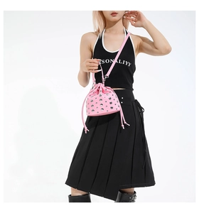 Detail of pink rivet bucket bag with silver studs and drawstring closure on shoulder strap