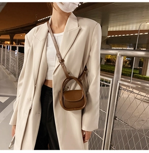 Detail view of a vintage dark brown leather mini handbag for children in an urban night setting