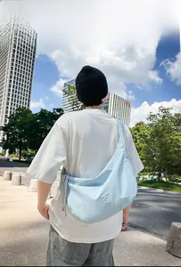 Streetstyle-Aufnahme einer hellblauen Nylon-Halbmondtasche mit verstellbarem Riemen