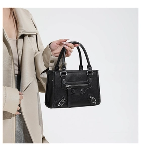 Detailed view of black pebbled leather texture and silver buckle on motorcycle bag