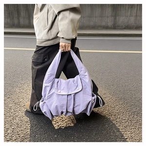 Close-up of light purple large tote bag with drawstring side pockets and nylon texture