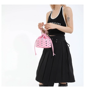 Detailed view of pink rivet bucket bag with drawstring closure and glossy leather finish