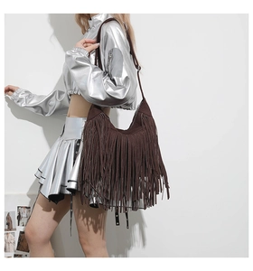 Close-up of bohemian dark brown suede fringe tote bag with long tassel details