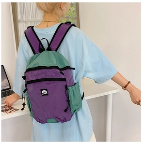 Rückansicht eines Kindes mit lila-grünem Kontrast-Schulrucksack aus Mesh-Nylon-Gewebe