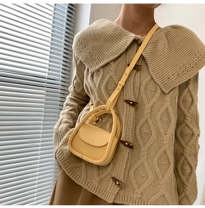 Detail showing a yellow mini leather crossbody bag for kids with natural light and shadow