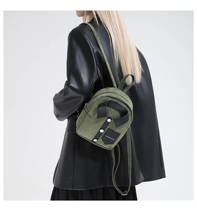 Detailed side view of a green shirt-shaped mini backpack worn with a black leather blazer