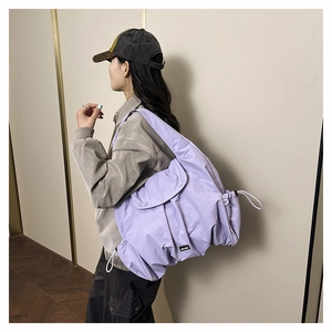 Detail of purple large-capacity nylon shoulder bag with drawstring closure and texture