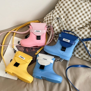 Macro detail of cartoon rain boot crossbody bags in pink, yellow, blue, and navy colors