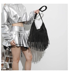 Detail of stylish black tassel tote bag paired with a metallic Y2K silver outfit