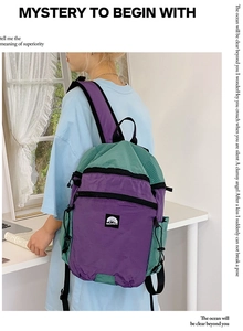 Detail eines lila-grünen Kontrast-Schulrucksacks mit reißfester Nylon-Textur-Oberfläche
