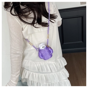 Detail of purple puffer down jacket crossbody bag with cartoon eyes and white fur trim