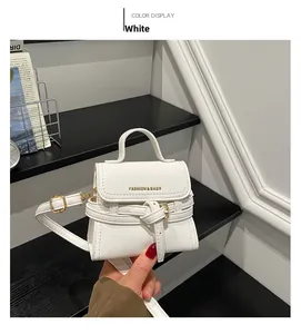 Detail of white leather mini bag with gold Fashion & Bags lettering and strap buckle
