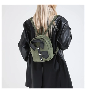 Detail of dark green suede mini backpack with creative jacket design and white buttons