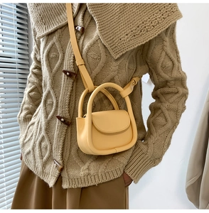 Close-up of a child wearing a cute pale yellow mini PU leather crossbody bag over a sweater