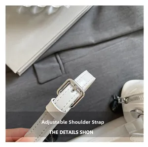 Détail de la bandoulière réglable en cuir verni blanc avec boucle en argent poli