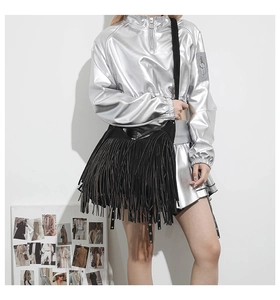 Detailed view of a black tassel tote bag with long fringes on a stylish model