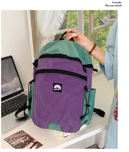 Detail des Color-Block-Rucksacks mit Ripstop-Nylon-Struktur und Bergbild-Logo-Aufnäher