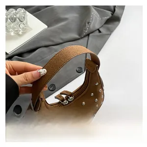 Detail of brown suede crescent bag with silver rivet studs and wide shoulder strap