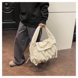 Close-up of beige nylon large capacity shoulder bag with drawstring detail and texture