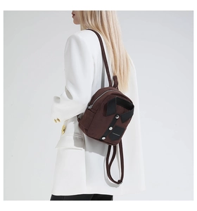 Detail of dark brown mini backpack with unique shirt collar design and metallic buttons