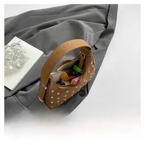 Brown suede punk rivet handbag interior showing storage for phone and lipstick