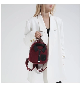 Detail of burgundy shirt-style mini backpack with collar and button accents