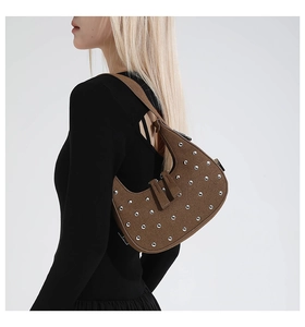 Detail of vintage brown suede hobo bag with silver metal studs and zip closure