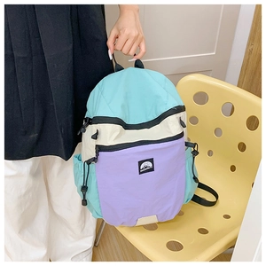 Detail eines farblich abgesetzten Rucksacks aus Nylon in Minzgrün und Lila mit Kordelzug