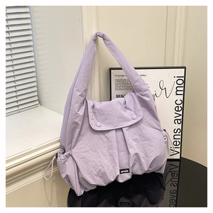 Close-up of light purple pleated shoulder bag with drawstring detail and double buckles