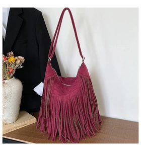 Close-up of bohemian dark red suede hobo bag featuring long stylish fringe tassels