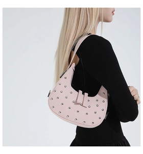 Pink punk rivet half-moon bag worn by model showing side profile and studded details