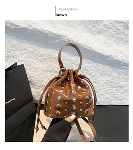 Detail of brown bucket bag with silver studs and glossy patent leather finish