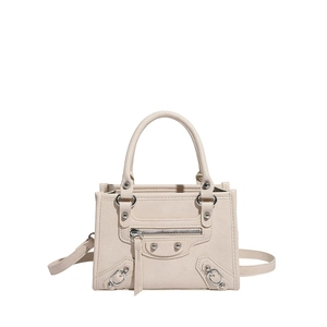 Beige motorcycle style rivet handbag with dual handles and adjustable shoulder strap