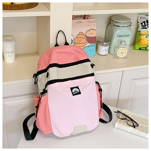 Detailansicht eines pink-grauen Schulrucksacks auf einem Tisch in wohnlicher Umgebung