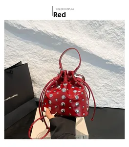 Detailed view of red patent leather bucket bag with silver metal studs and drawstring
