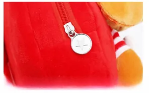 Detailed close-up of a silver star zipper pull on a soft red plush child backpack