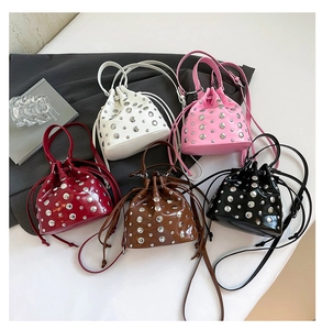 Close-up of studded bucket bags in five colors with drawstring closure and metal rivets