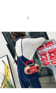 Dettaglio di una borsa a tracolla stile radio vintage con accenti rossi e finitura metallica