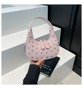 Detailed close-up of a pink hobo bag with silver metallic studs and dual zipper closure