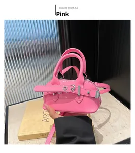 Detailed shot of pink patent leather mini shell bag with punk studs and buckle straps