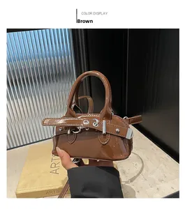 Detailed view of the brown patent leather handbag with silver metallic buckle accents