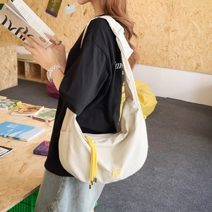 Minimalistische beige Umhängetasche für Kinder in Halbmondform mit gelber Quaste