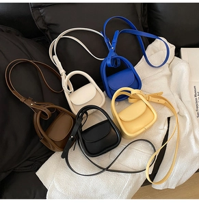 Detail shot of mini vintage tote bags in brown, blue, yellow, cream, and black colors