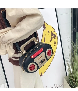 Dettaglio della borsa a tracolla stile radio vintage con borchie dorate e griglia rossa